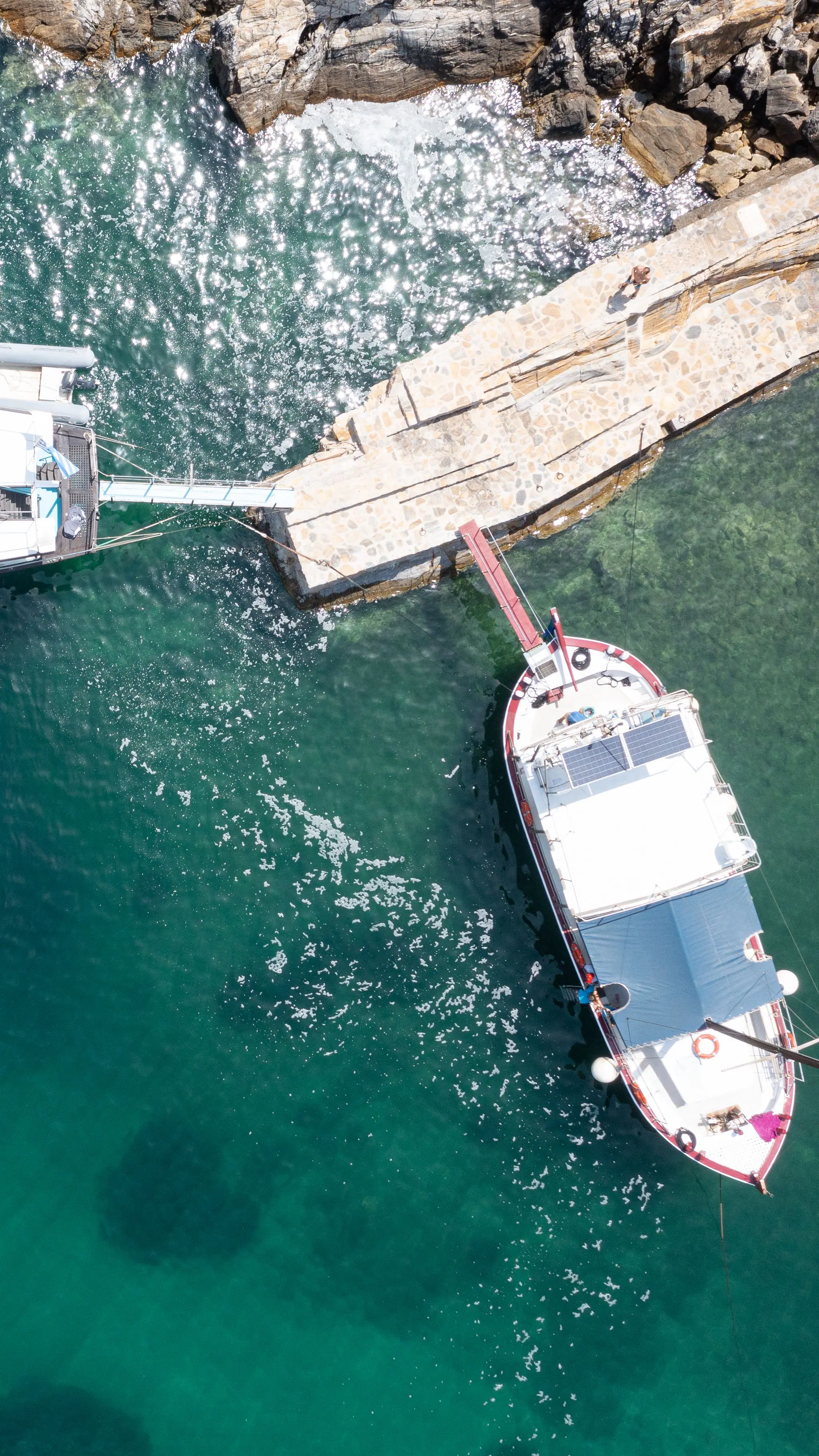 A boat moored in clear turquoise water, seen from directly above