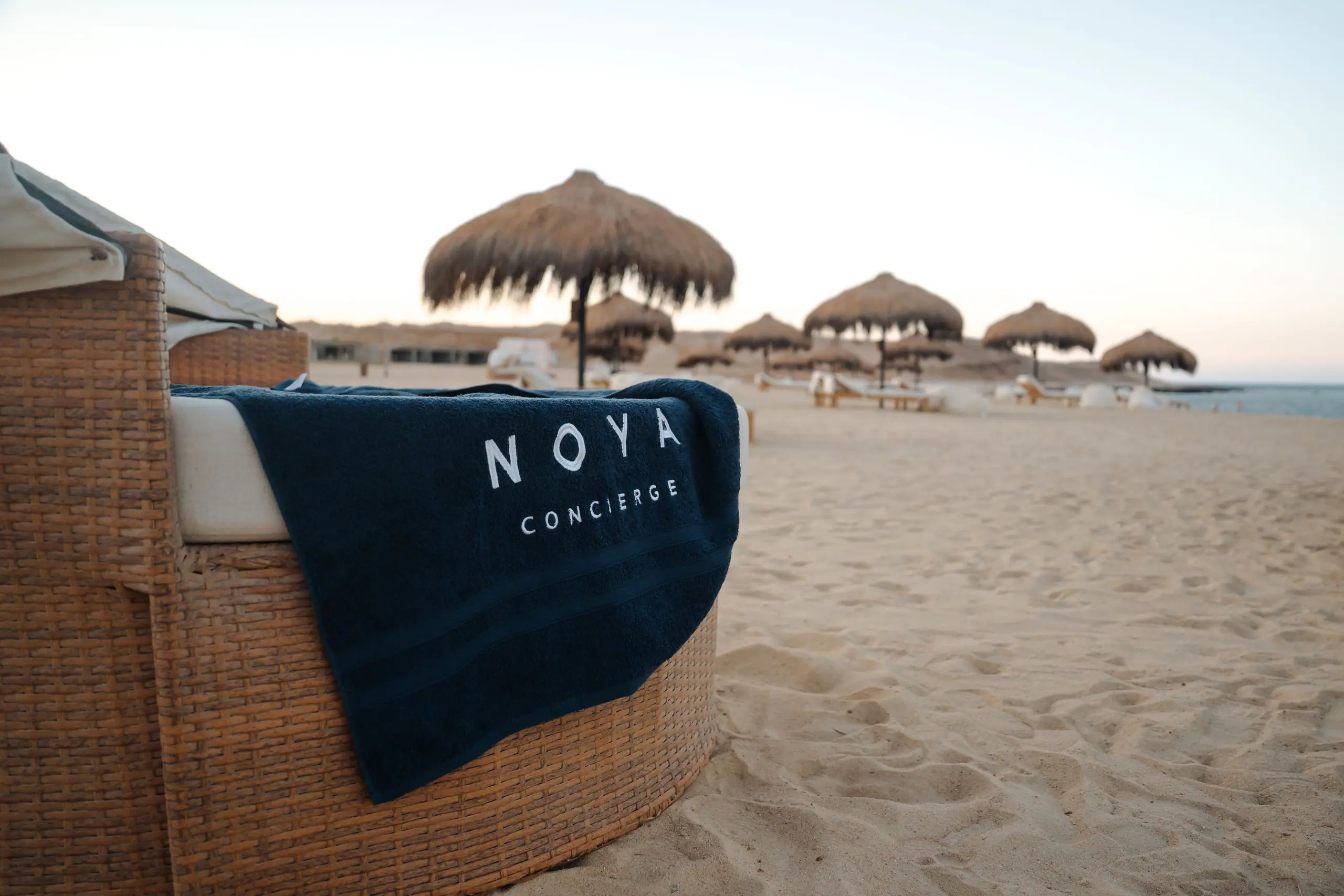 A NOYA towel on a daybed by the sea