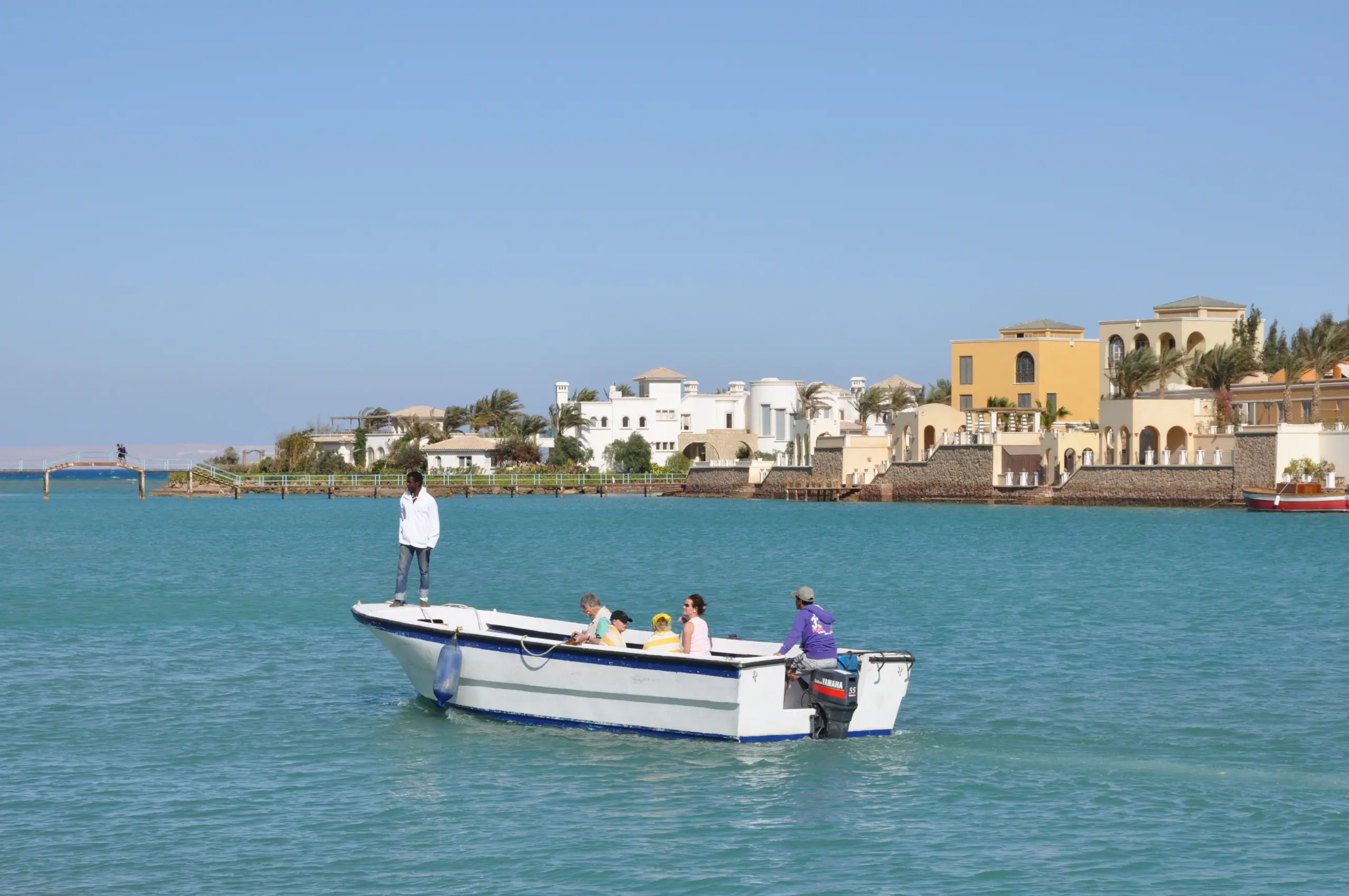 A small boat crossing the lagoon at El Gouna, villas on the far shore