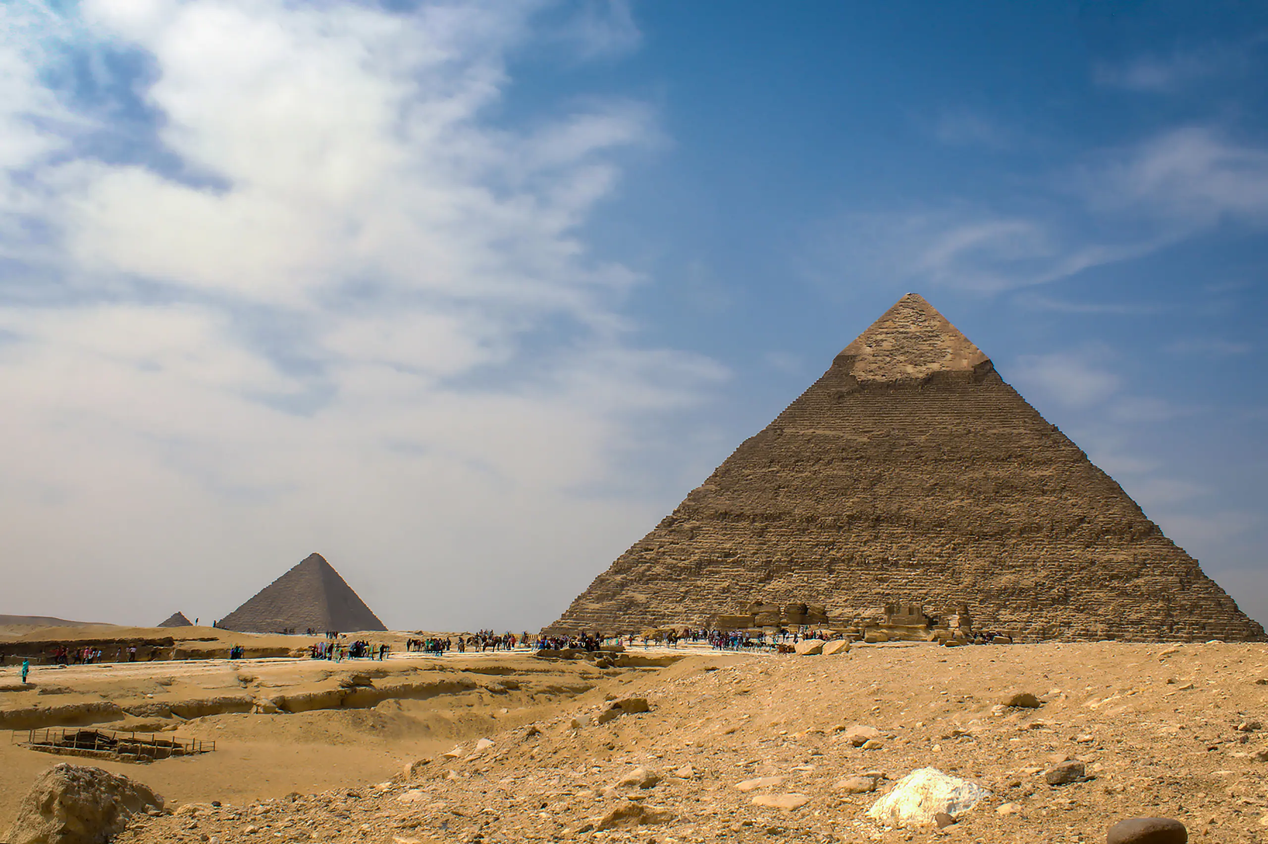 The Pyramid of Khafre on the Giza plateau, its casing stones still at the apex, a smaller pyramid beyond