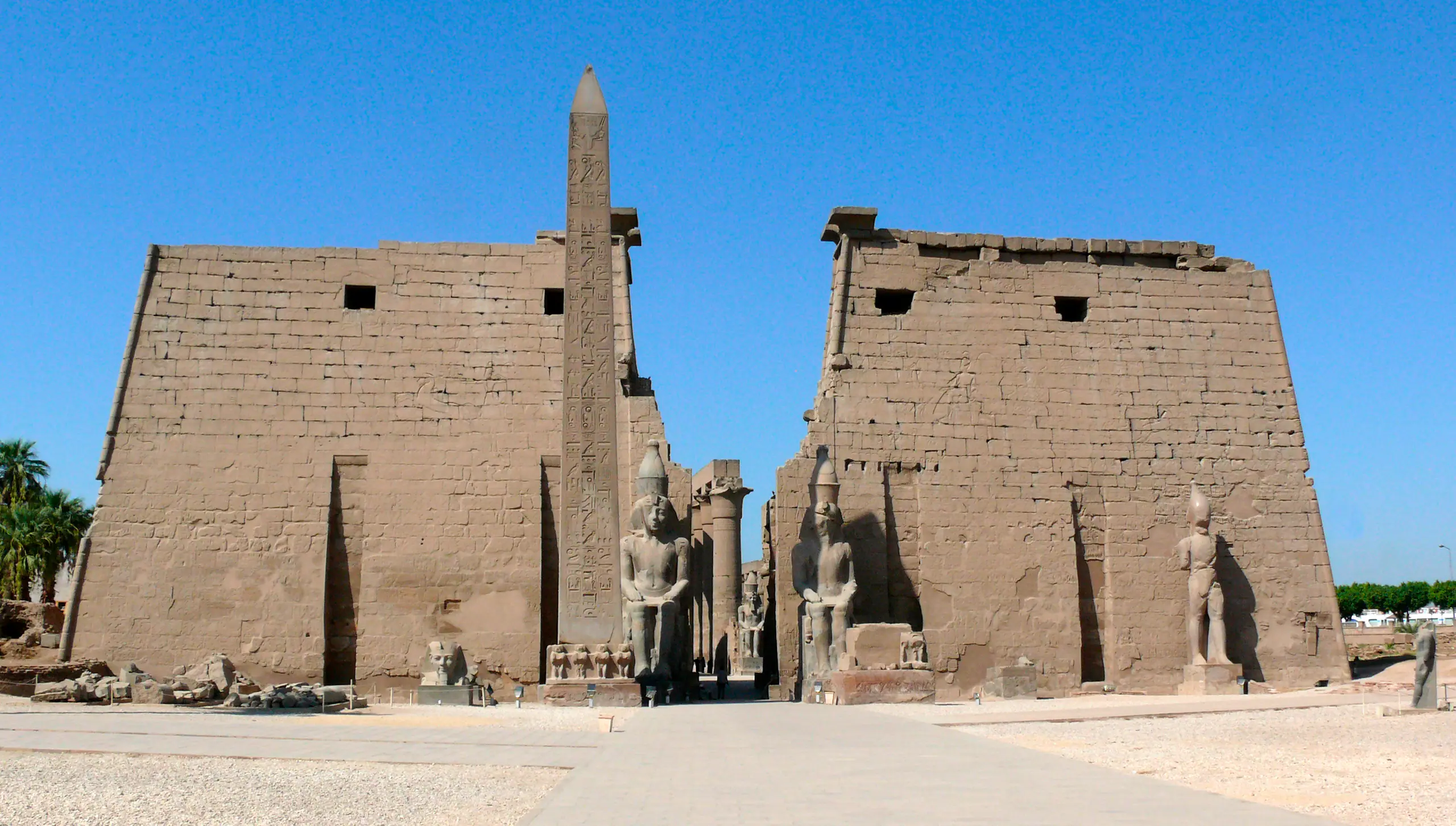 The first pylon of Luxor Temple, its obelisk and seated statues of Ramesses II under an open sky