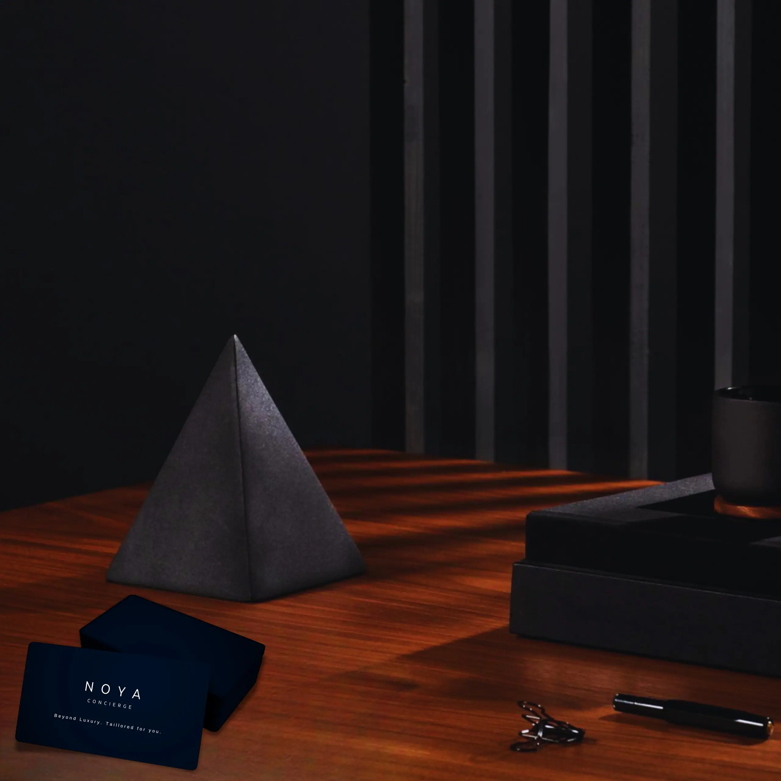 A NOYA gift set beside a black pyramid sculpture