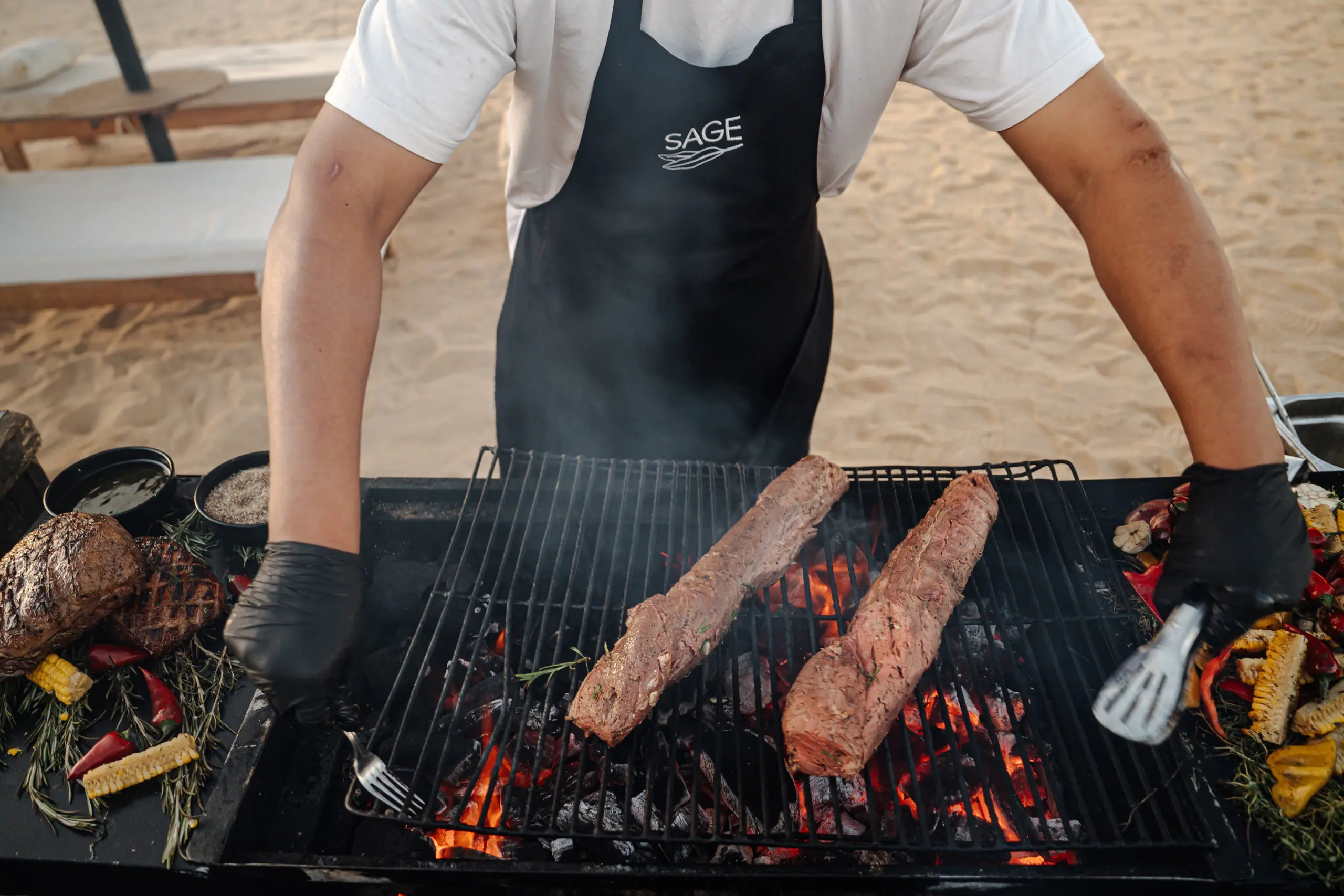 Chefs at an open grill on the beach