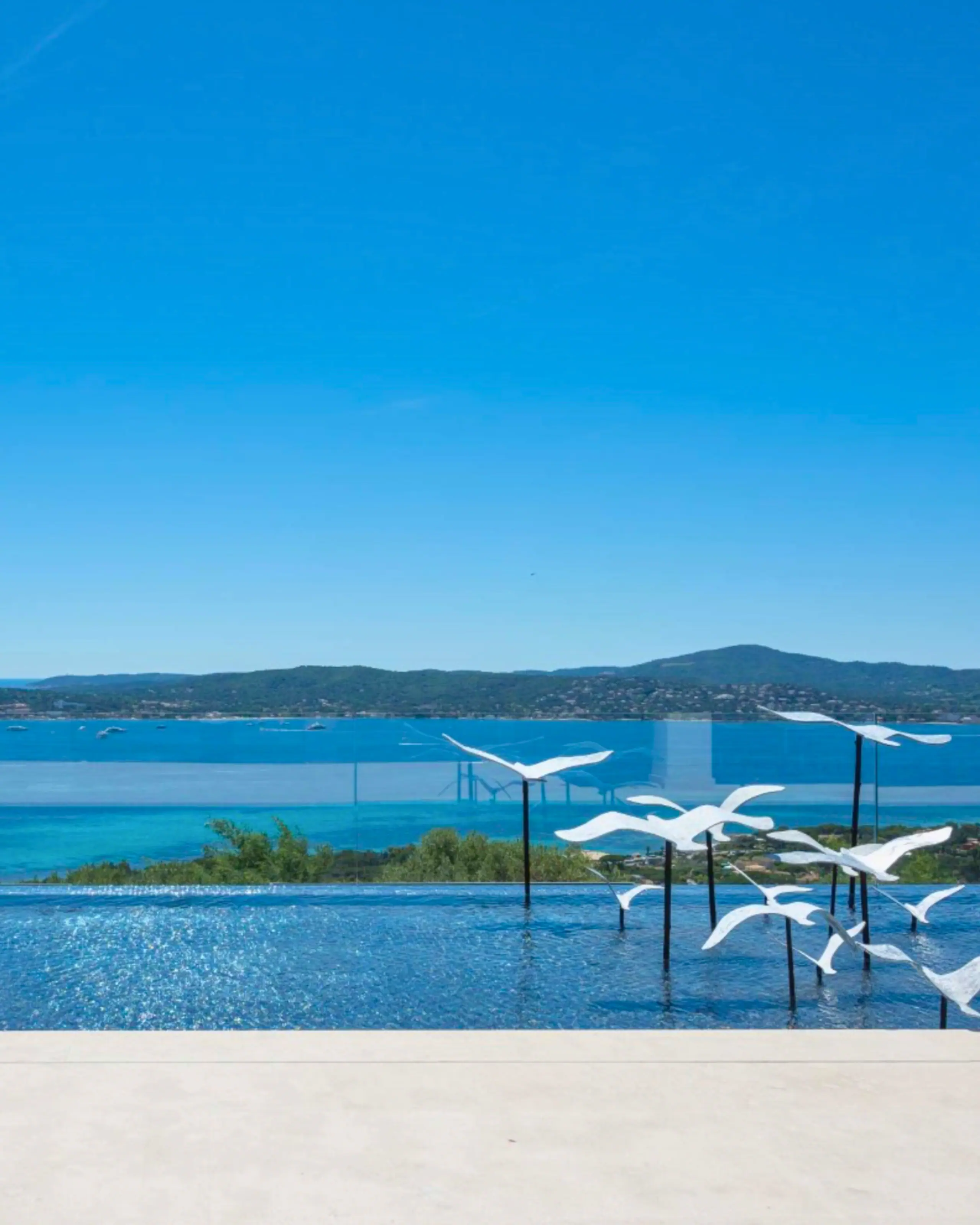 An infinity pool with bird sculptures above the bay of Saint-Tropez