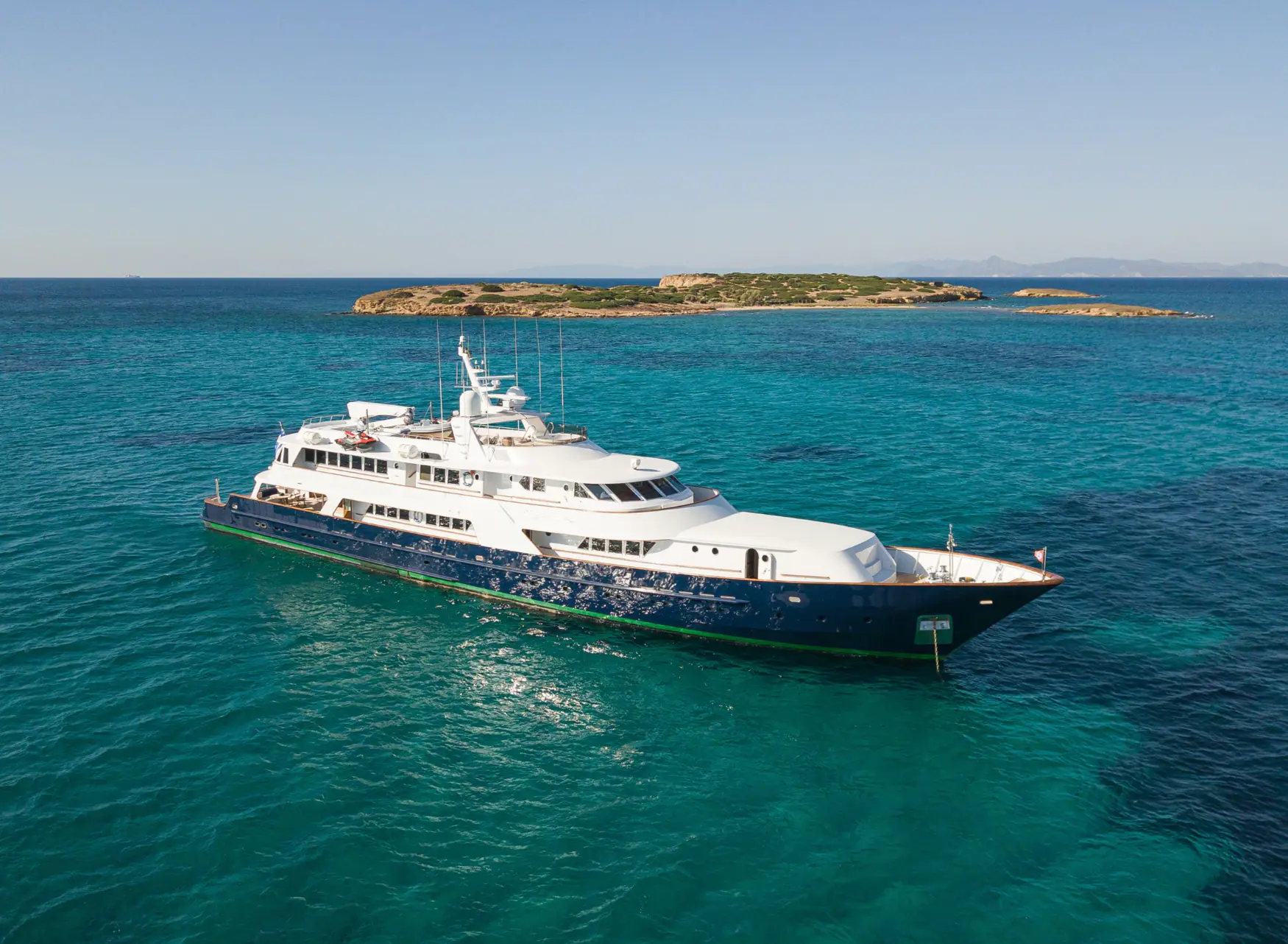 Wind of Fortune at anchor in turquoise water off a small island