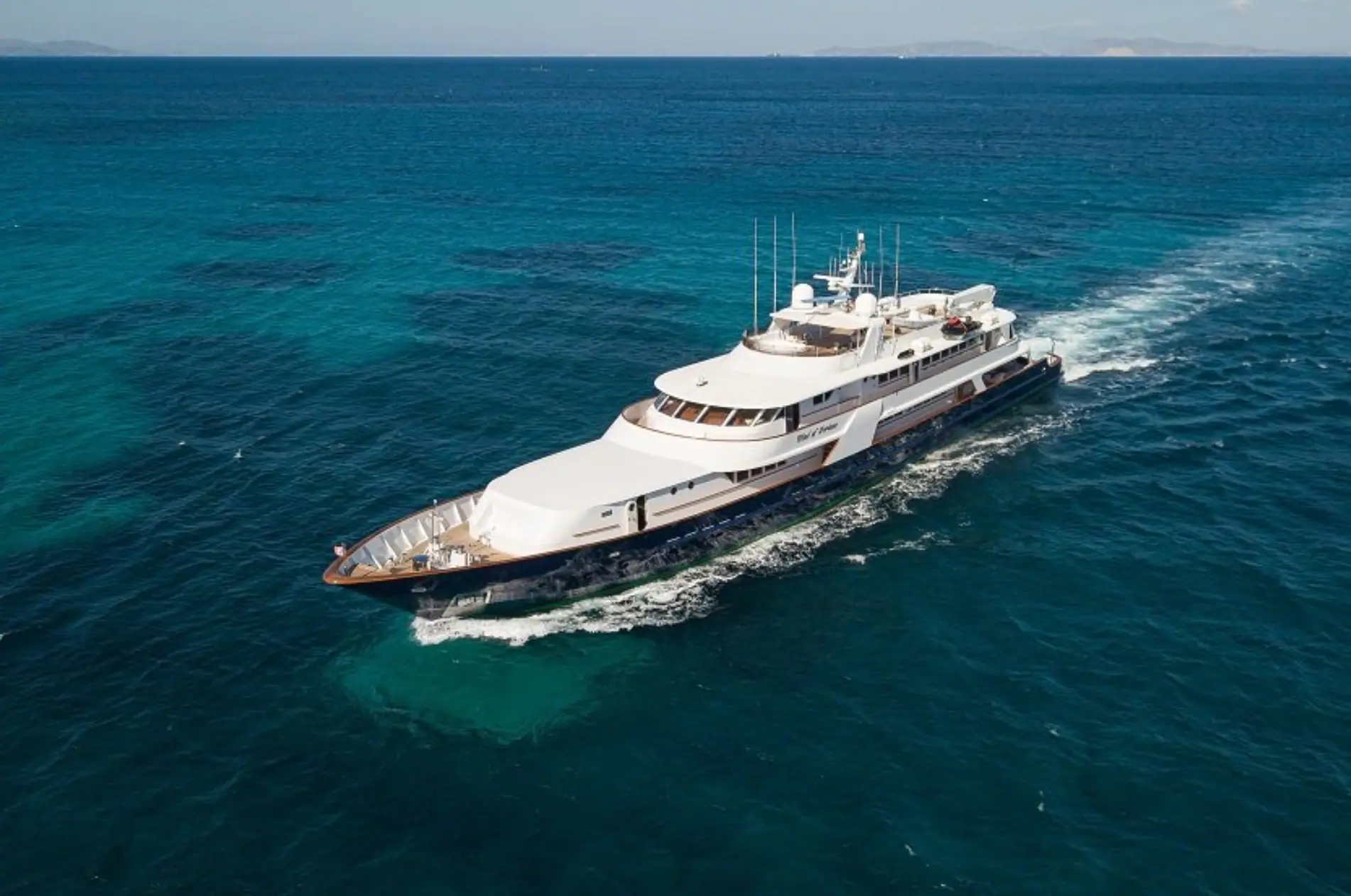 Wind of Fortune under way across deep teal water